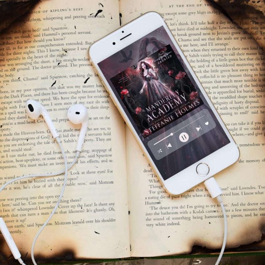 Haunted audiobook on iphone with print book in background